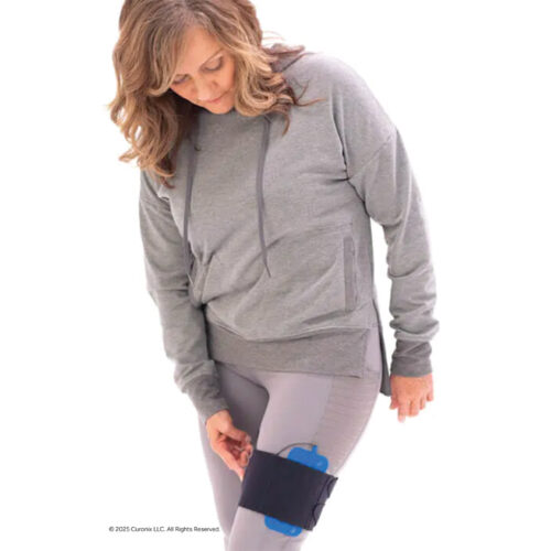 A woman is wearing a Freedom System wearable on her thigh.