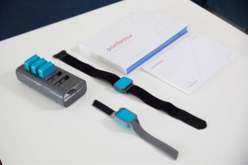 A flat lay of the separate components of the Parkinson’s disease monitor on a table.